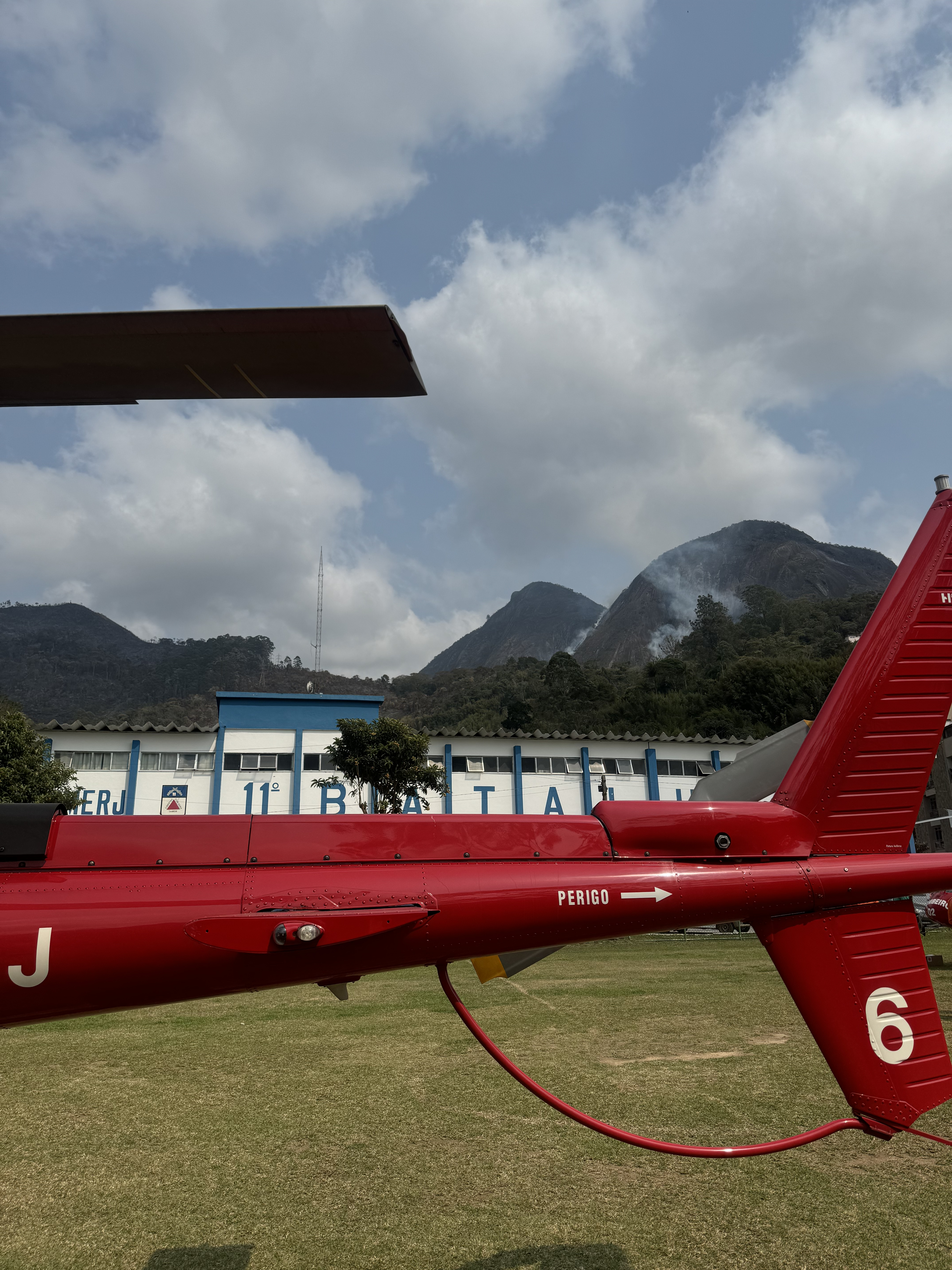 Helicóptero do CBMERJ com focos de incêndio ao fundo